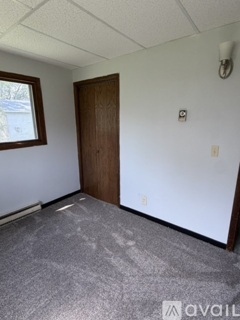 A room with a wooden door and a window.