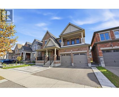 A large, two-story house with a garage is situated on a street with other houses.
