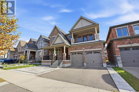 A large, two-story house with a garage is situated on a street with other houses.