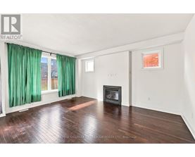 A spacious room with a fireplace and a window with green curtains.