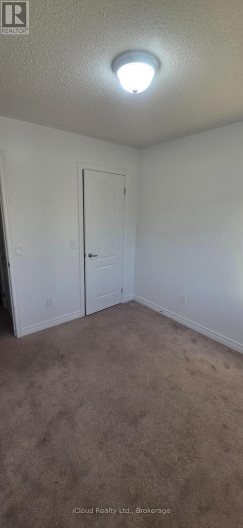 A room with a carpeted floor and a white door.