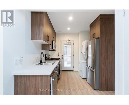 A modern kitchen with wooden cabinets and stainless steel appliances.