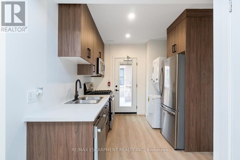 A modern kitchen with wooden cabinets and stainless steel appliances.