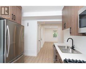 A kitchen with a stainless steel refrigerator and wooden cabinets.