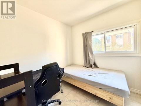 A bedroom with a bed, chair, and window.