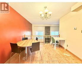 A dining room with a wooden table and chairs.