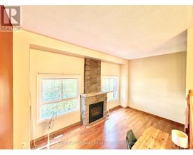 A living room with a fireplace and a fan.