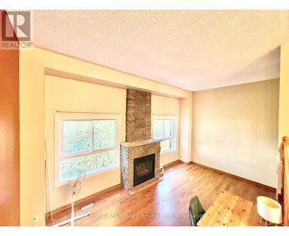 A living room with a fireplace and a fan.