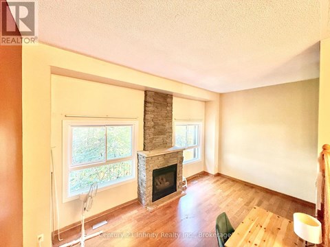 A living room with a fireplace and a fan.