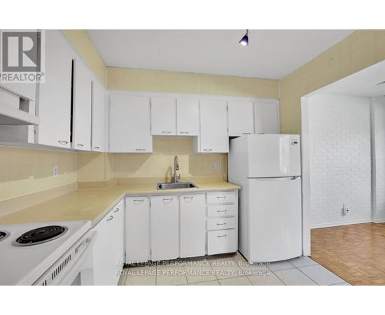 A kitchen with white cabinets and appliances.