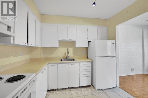 A kitchen with white cabinets and appliances.