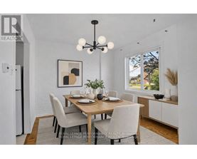 A dining room with a wooden table and chairs.