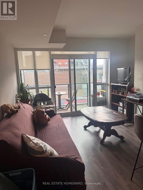 A living room with a couch, a table, and a television.