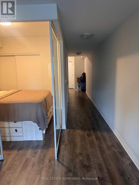 A bedroom with a bed and a wooden floor.