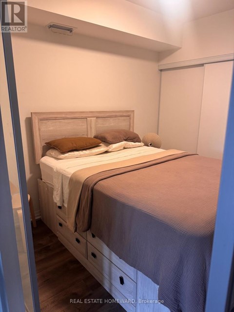 A bedroom with a bed, pillows, and a blanket.