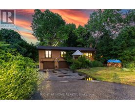 A house with a driveway and a sunset in the background.