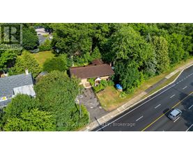 A bird's eye view of a house with a driveway and a car parked in front.