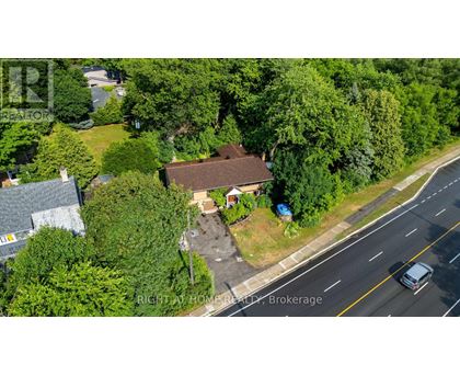 A bird's eye view of a house with a driveway and a car parked in front.