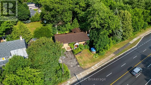 A bird's eye view of a house with a driveway and a car parked in front.