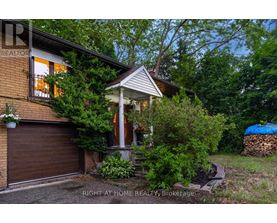 A house with a brown garage door and a porch with a white railing.