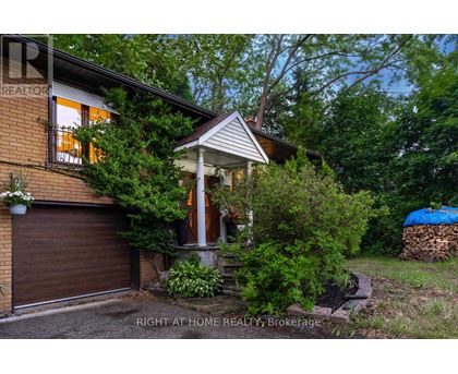 A house with a brown garage door and a porch with a white railing.