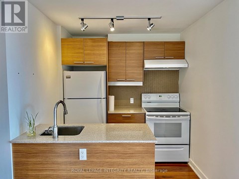 A kitchen with a sink, stove, and refrigerator.