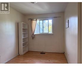 A room with a window and a shelving unit.