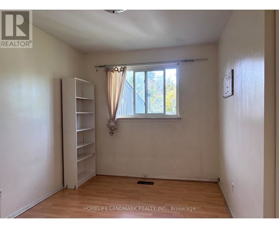 A room with a window and a shelving unit.