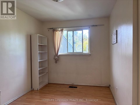 A room with a window and a shelving unit.