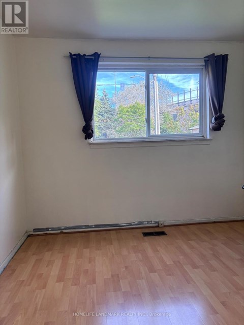A room with a window and wooden flooring.