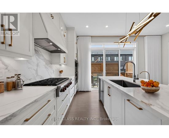 A modern kitchen with white cabinets and a marble countertop.