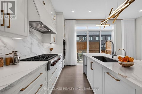 A modern kitchen with white cabinets and a marble countertop.