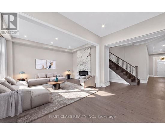 A spacious living room with a staircase leading to the upper floor.
