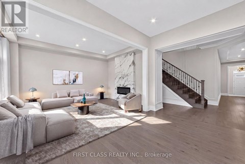 A spacious living room with a staircase leading to the upper floor.
