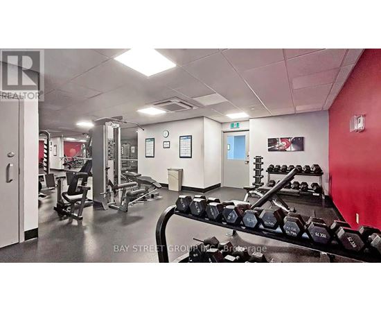 A gym with a variety of equipment including dumbbells and weight machines.