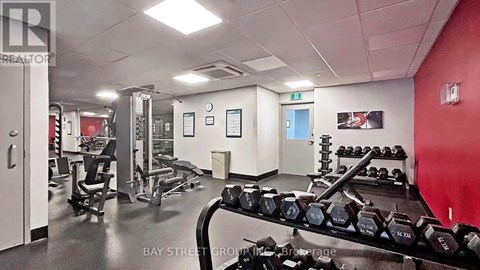 A gym with a variety of equipment including dumbbells and weight machines.