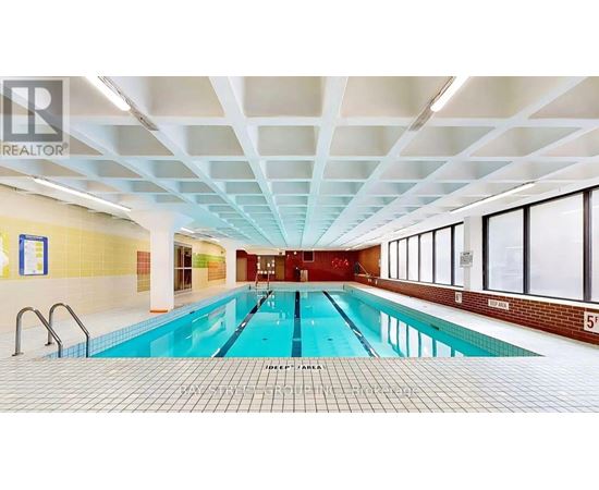 A large indoor swimming pool with a tiled floor and ceiling.