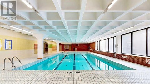 A large indoor swimming pool with a tiled floor and ceiling.