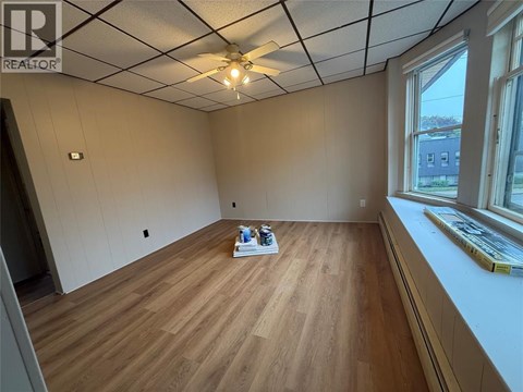 A room with wooden flooring and a ceiling fan.