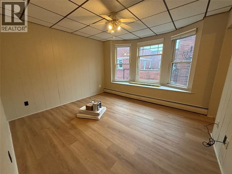 A room with wooden floors and a ceiling fan.
