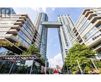 A modern cityscape with tall buildings and a pedestrian walkway.