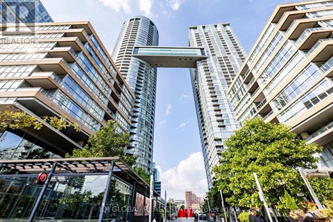 A modern cityscape with tall buildings and a pedestrian walkway.