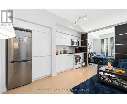 A modern kitchen with white cabinets and a stainless steel refrigerator.