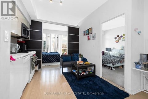 A living room with a couch, a coffee table, and a washing machine.