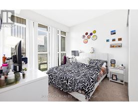 A bedroom with a large bed and a window overlooking a cityscape.