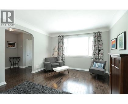 A living room with a grey couch and a wooden floor.