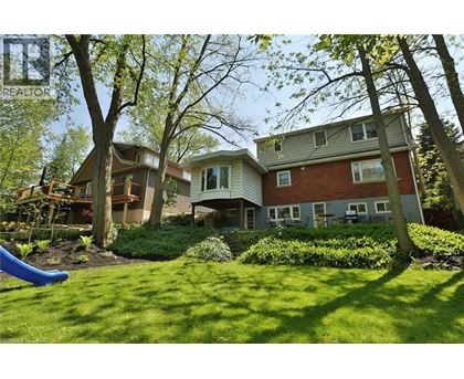 A house with a green lawn and trees in the background.