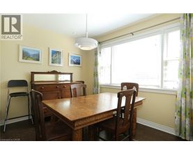 A dining room with a wooden table and chairs.