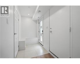 A hallway with white walls and a tiled floor.