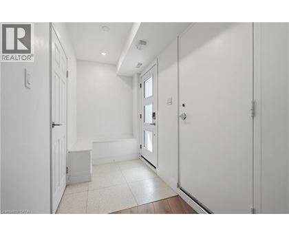 A hallway with white walls and a tiled floor.